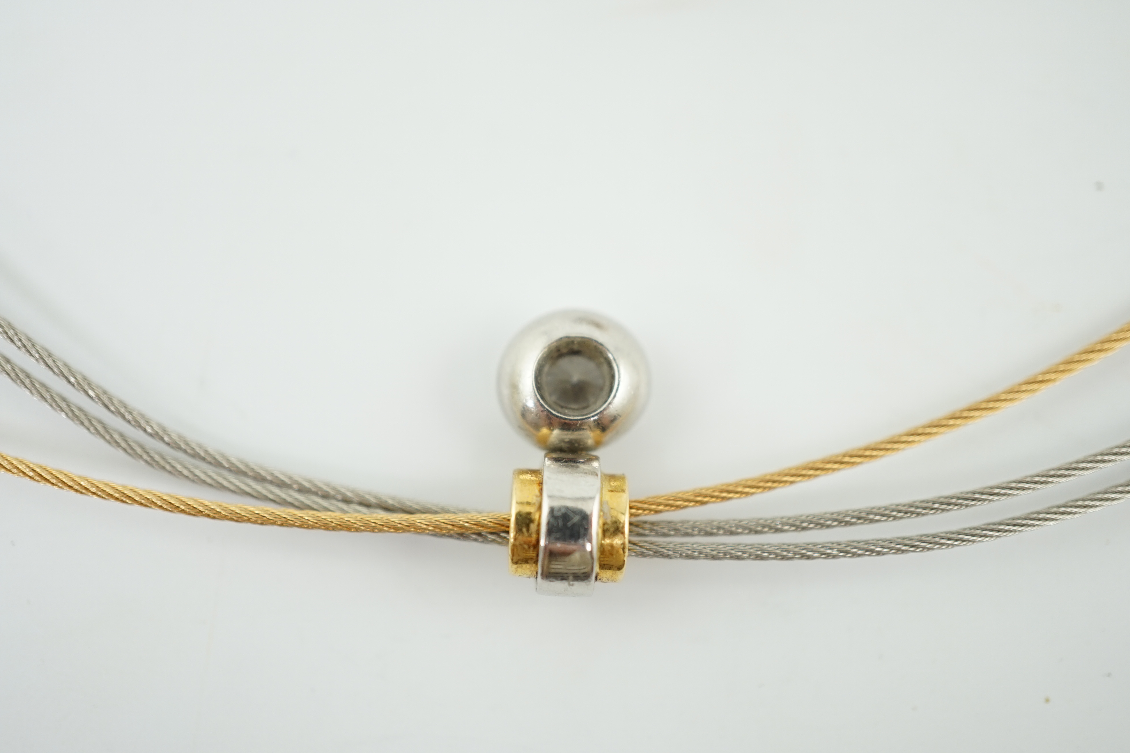 A modern platinum and 18k gold triple strand necklet, with round and princess cut diamond set pendant and a pair of matching earrings